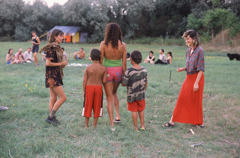 Adults and children gathered in the meadow during the ritual at dusk.